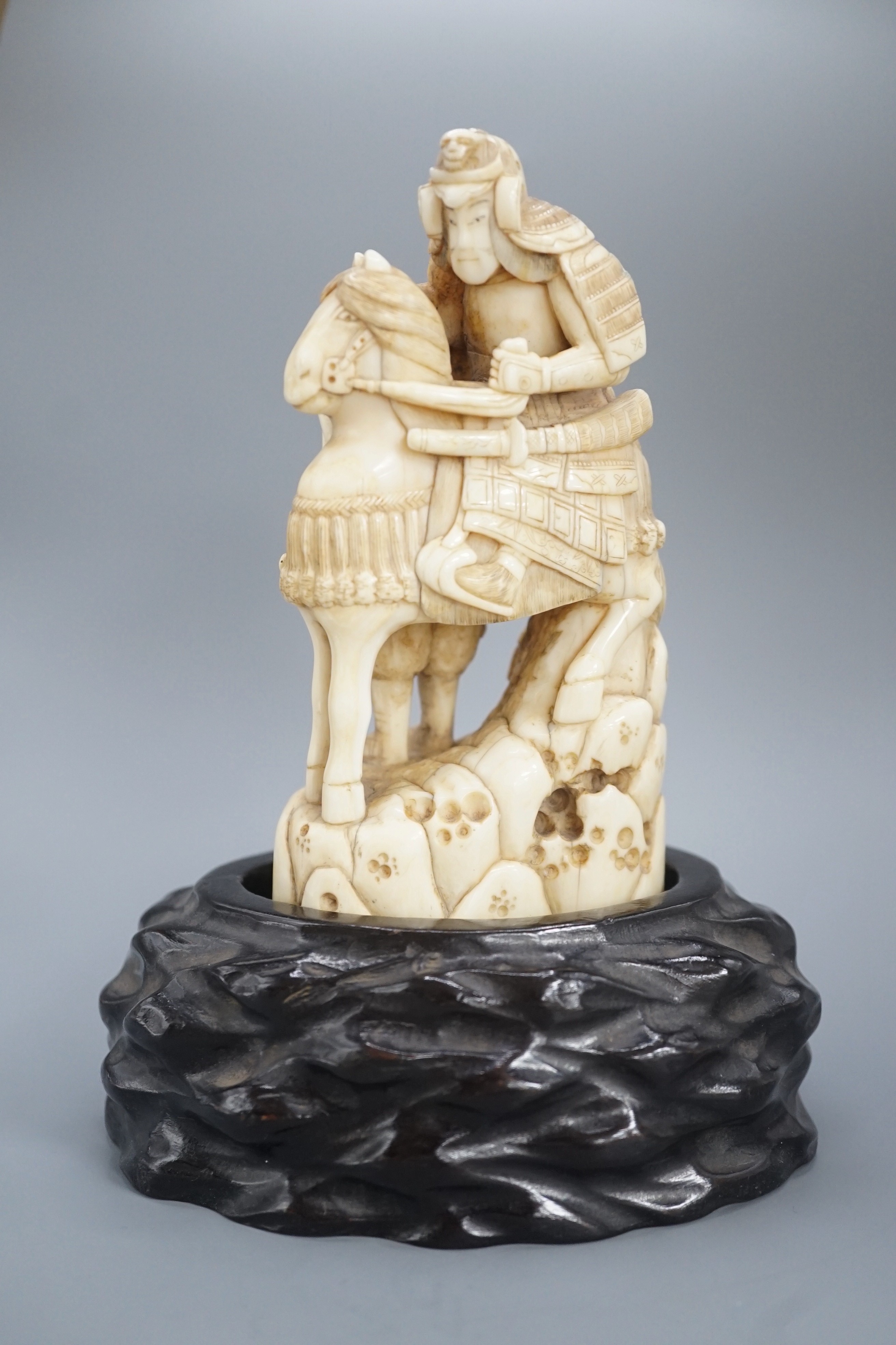 A Japanese ivory okimono of a samurai on horseback, with an attendant behind him, signed, late 19th century 12cm